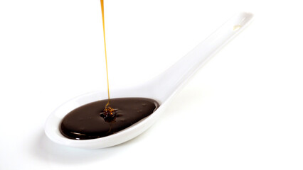 Liquid sunflower lecithin pouring on a spoon isolated on white Background