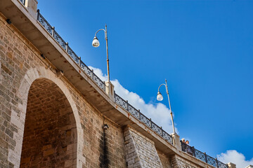 Canvas Print - Polignano a Mare, Puglia, Italy: Ponte di Polignano bridge with Bastione di Santo Stefano and Lama Monachile beach in background, Apulia, Italy, Cala Paura gulf, province of Bari