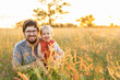 © Austockphoto - Portrait of young father in his early twenties with baby girl in long grass on Australian farm
