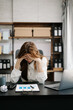 © Nuttapong punna - Asian business woman is stressed, bored, and overthinking from working on a tablet at the office.