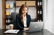 © Nuttapong punna - Business asian woman using tablet and laptop for doing math finance on an office desk, tax, report, accounting, statistics, and analytical research concept in office