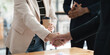 © Natee Meepian - End of meeting handshake of two happy businessmen after a contract agreement to be a team collaboration partnership. Colleagues applaud
