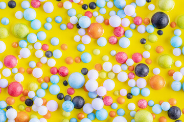 Wall Mural - Colorful balls in yellow paint, abstract colorful background. Background with colorful balls in different sizes. Sphere of balls on pastel color.