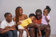 © unai - Portrait of black African ethnicity family with children on the sofa at home having fun