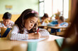 © Drazen - Hispanic schoolgirl writing exam during class in classroom.