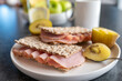 Peppered ham sandwich with crispbread and kiwi for breakfast on a dining table