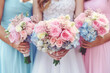 Wedding flowers, bride and bridesmaids holding their bouquets at wedding day. Happy wedding concept