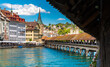 Picturesque view of the street Rathausquai at the river Reuss in the Old Town of Lucerne from the Kapellbrücke (Chapel Bridge) on a sunny day with a blue sky.