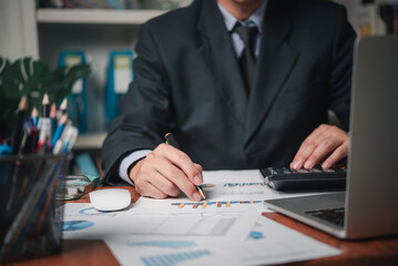 Wall Mural - businessman working accountant document graph and chart on desk using calculator for calculate finance report in office.