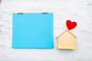 Wall Mural - Blank blue card with wooden house model and red heart on white background, buy new hosue, property investment, real estate business