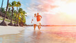© Soloviova Liudmyla - Couple in love hugging while walking on a sandy exotic beach. They have an evening walk by Trou-aux-Biches seashore on Mauritius island. People relationship and tropic honeymoon vacations concept