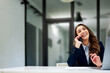 © bnenin - A pretty businesswoman talking on a mobile phone and laughing at the office.