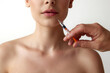 © master1305 - Cropped image of female face, lips doing cosmetological injections against white studio background. Lip augmentation. Concept of natural female beauty, body and skincare, cosmetology, health, ad