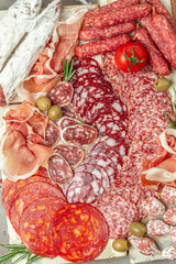 Wall Mural - Salami, sliced ham, sausage, prosciutto, bacon. Meat antipasto platter wirh wine. Food recipe background. Close up