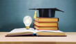 books with graduation hat on light bulb education learning on school