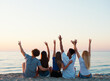 © Designpics - Happy group of friends raising their hands to the sky