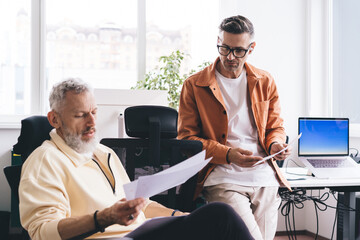 Wall Mural - Focused colleagues with documents working on project in office