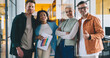 © BullRun - Group of multiethnic colleagues standing in office corridor