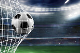 Fototapeta Sport - Ball scores a goal on the net in a football match