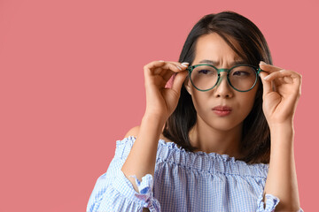 Canvas Print - Beautiful Asian woman in stylish eyeglasses squinting on pink background, closeup