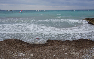 several windsurfers on the ocean on a windy day in the calanques near Marseille, France