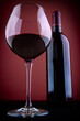 © Designpics - Glass and bottle of red wine, against a red vignetting background.