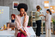 © bernardbodo - African-American business woman looking down while having unpleasant conversation over phone.