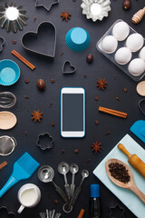 Baking background with eggs and kitchen tools: rolling pin, wooden spoons, whisk, sieve, bake ware, shape cookie   cutter and mobile phone mockup on dark wooden background. Vertical orientation with c