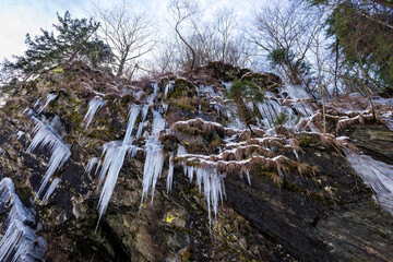 Sticker - Mountain slopes covered in ice and icicles as the winter snow is melting during cold temperature, forming ice waterfalls along the slopes