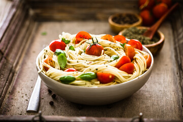 Wall Mural - Italian cuisine. Pasta with olive oil, garlic, basil and tomatoes. Spaghetti with tomatoes