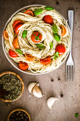 Wall Mural - Italian cuisine. Pasta with olive oil, garlic, basil and tomatoes. Spaghetti with tomatoes