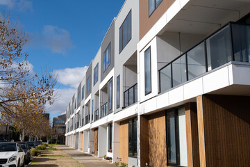 Wall Mural - Building of a row of brand new 3-story residential townhouses in a suburb of Australia. Concept of the housing market, real estate development, property investment and home ownership.