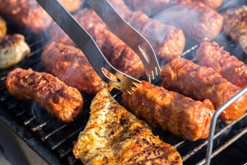 Wall Mural - Close up of traditional Romanian food made of pork/beaf meat called mici or mititei fried on mangal barbeque grill