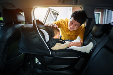 father take care his infant baby in car seat.