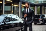 Fototapeta Do przedpokoju - Handsome young businessman using mobile phone while standing outdoors near car