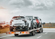 canvas print picture - Emergency roadside assistance on the highway. side view of the fltabed tow truck with a damaged vehicles after a traffic accident.
