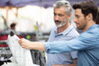 © auremar - two men looking at a shirt on a street market