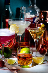 Wall Mural - Alcoholic cocktails set, strong drinks and aperitifs, bar tools, bottles on dark green background, hard light. Martini vodka, pink lady, aperol spritz, margarita, old fashioned cocktail in glasses