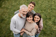 © LIGHTFIELD STUDIOS - Overhead view of cheerful children hugging middle aged parents and looking at camera while celebrating parents day together at backyard in june, quality time with parents concept