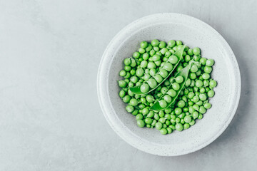 Wall Mural - Pea. Green peas bowl on gray stone background, top view