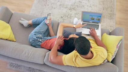 Canvas Print - Laptop, holiday planning and a couple on a sofa in the living room of their home together from above. Computer, phone or technology with a young man and woman searching for a vacation destination