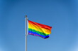 © Tatiana Kolosovskaya - The rainbow flag of the LGBTQ community flies against blue clear sky