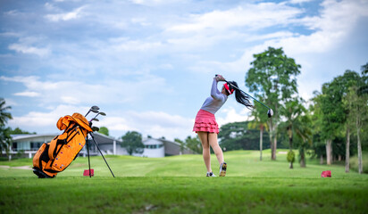 Sticker - Professional woman golfer teeing to hole in player tournament competition at golf course for winner with green golf background.	