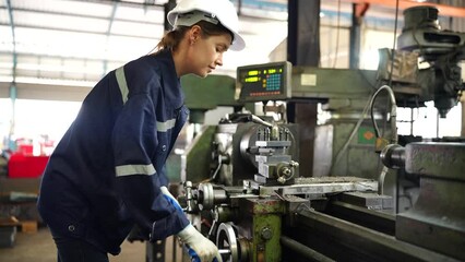 Wall Mural - Worker operating in manual lathe.   industrial Engineer manager man demonstration and training mechanic worker woman operating industrial lathe machine and checking quality control