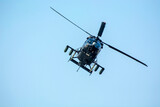 Fototapeta  - Combat helicopter is flying against isolated blue sky. Combat helicopter attack enemy.