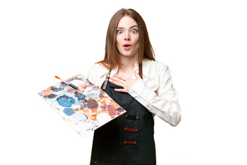 Poster - Young artist woman holding a palette over isolated chroma key background surprised and shocked while looking right