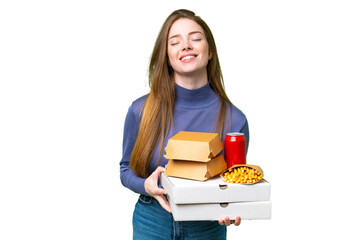 Sticker - Young pretty woman holding pizzas and burgers over isolated chroma key background posing with arms at hip and smiling