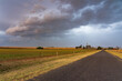 © Austockphoto - Rain falling from a colourful dramatic stormfront over a country road