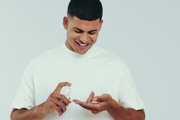 Embracing male skincare with face wash, young man applying the beauty product