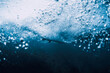 Wave underwater and surfer on surfboard in ocean. Underwater crashing wave and surfboard in transparent water